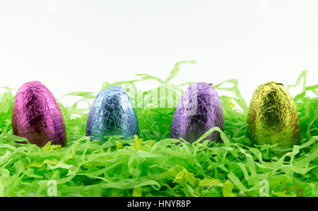 Easter Eggs on green shredded paper with yellow chickens Stock Photo
