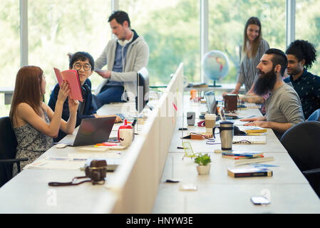 Entrepreneurs working in open plan office Stock Photo