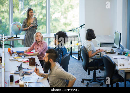 Colleagues sharing ideas in casual office space Stock Photo