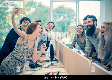 Cheerful colleagues posing for a selfie in casual office Stock Photo