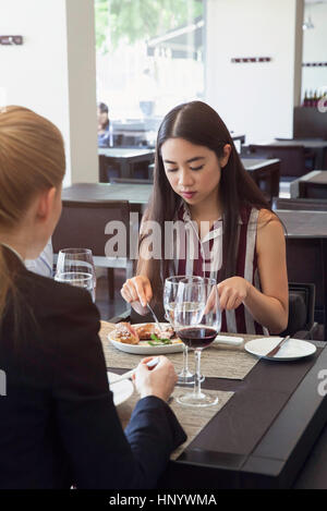 Woman dining in restaurant with friend Stock Photo