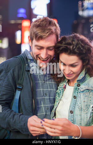 Young couple reading text message received on cell phone Stock Photo