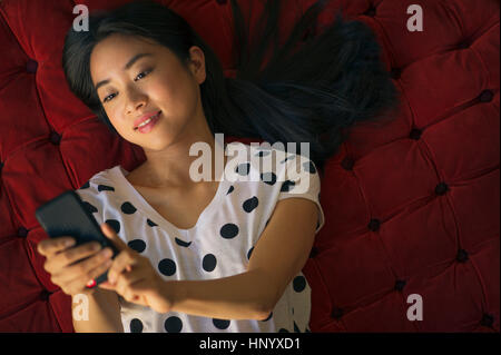 Young woman sending text message using smartphone Stock Photo