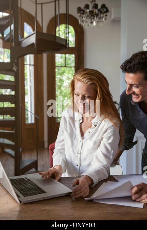 Couple working on laptop computer together at home Stock Photo