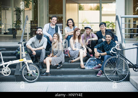 Group of creative colleagues sitting together outdoors Stock Photo