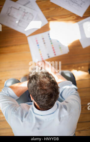 Man contemplating blueprints and color swatches Stock Photo