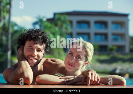 Couple relaxing at poolside, portrait Stock Photo