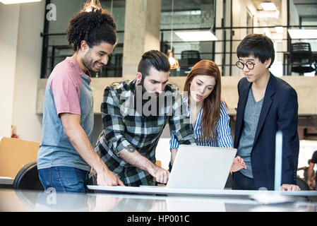 Creative colleagues working together on laptop computer Stock Photo