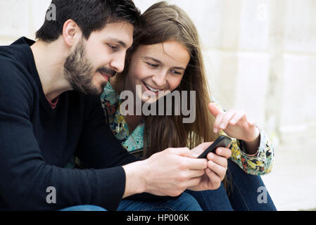 Couple using smartphone together Stock Photo