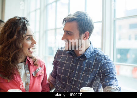 Cheerful couple talking together in coffee shop Stock Photo
