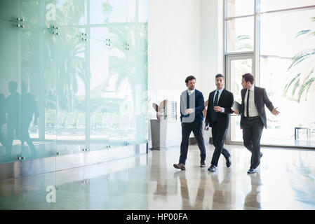 Business associates chatting while walking together Stock Photo