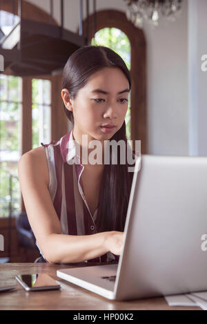 Young woman working on laptop computer Stock Photo