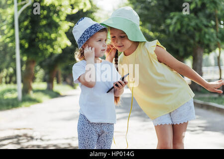 Happy girl with headphones to share music Stock Photo