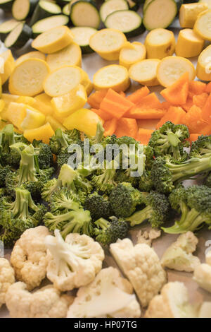 Brightly colored Cauliflower, Broccoli, Bell Peppers and Zucchini being prepared to be roasted  for a dinner meal Stock Photo