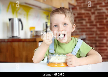 Little boy having breakfast in the kitchen Stock Photo