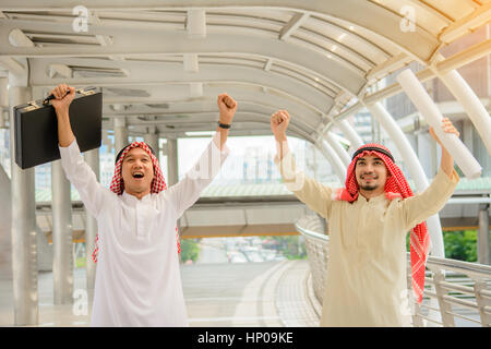 Sucess arab business people feeling happy with their work with city background. Stock Photo