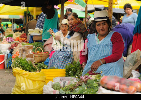 Ecuador, Gualaceo - August 22: Ecuadorian ethnic women in national clothes selling agricultural products and other food items on a market Stock Photo