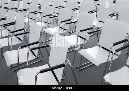 Rows of empty white modern chairs in a conference room Stock Photo