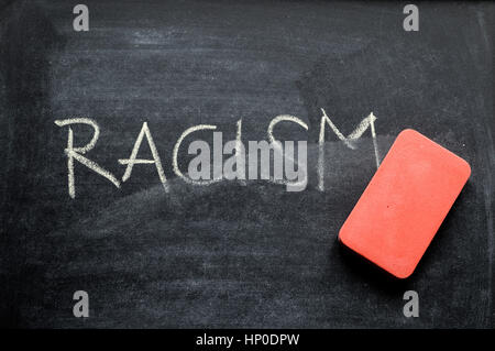 erasing racism, hand written word on blackboard being erased concept Stock Photo