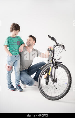 father and son with new bicycle on white Stock Photo