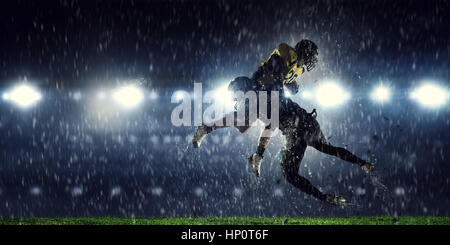 Two american football players fighting for ball. Mixed media Stock Photo