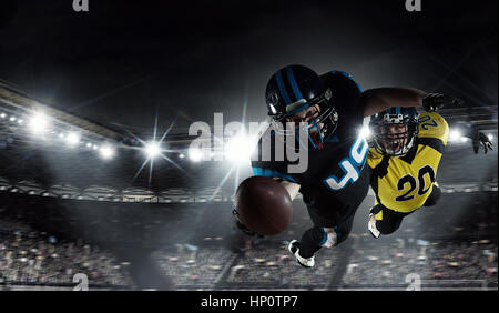 Two american football players fighting for ball. Mixed media Stock Photo