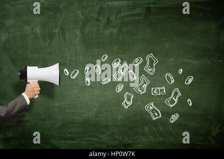 Hand of businessman holding megaphone against chalkboard background Stock Photo