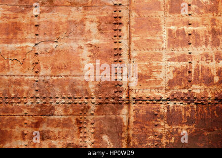 Old rusted ship hull fragment, iron sheets with rivets, background photo texture Stock Photo