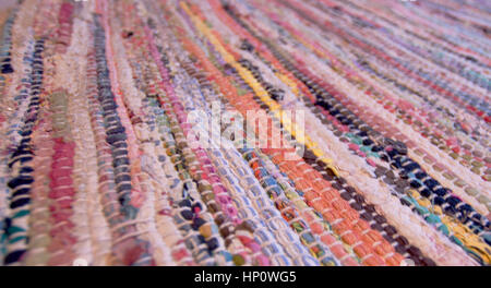 Colourful handmade patched rug on the floor,blurred in background.Modern and traditional and popular around the world house decor item.Texture. Stock Photo