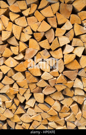 firewood - seasoned kiln-dried split logs neatly stacked background Stock Photo