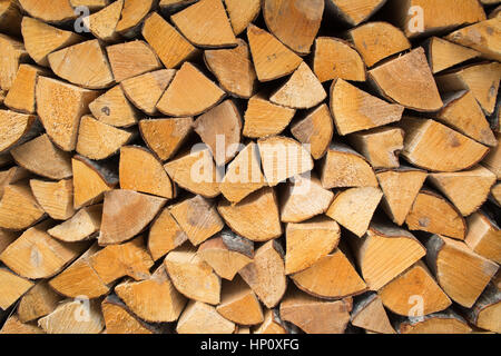 firewood - seasoned kiln-dried split logs neatly stacked background Stock Photo