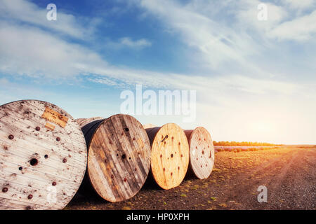 Large rolls of wires against the blue sky at sunset. Stock Photo
