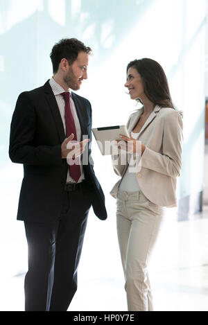 Business associates having pleasant conversation in office corridor Stock Photo