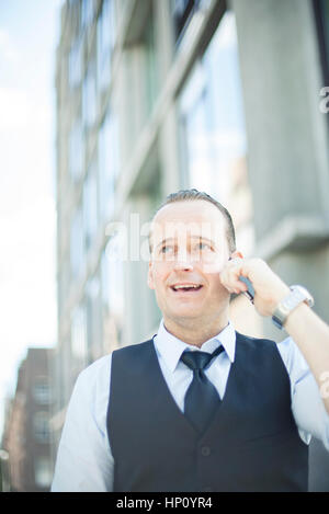 Businessman talking on cell phone outdoors Stock Photo