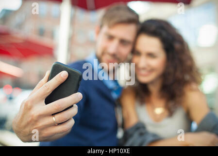 Man using smartphone to photgraph himself with his wife Stock Photo