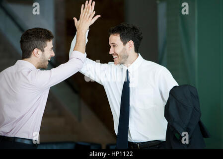 Business colleagues exchanging high five Stock Photo