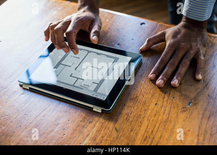 Architect using digital tablet to view plans Stock Photo