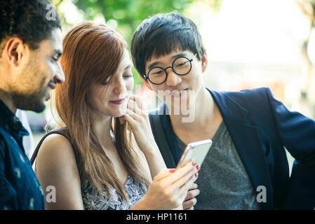 Young adult friends watching video on smartphone together Stock Photo