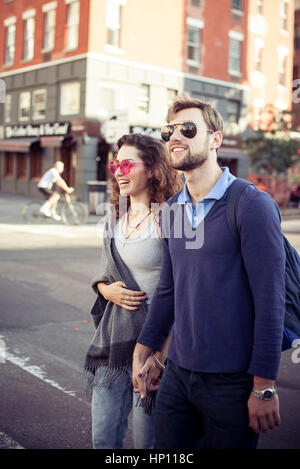 Couple crossing city street together Stock Photo