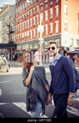 Couple crossing city street together Stock Photo