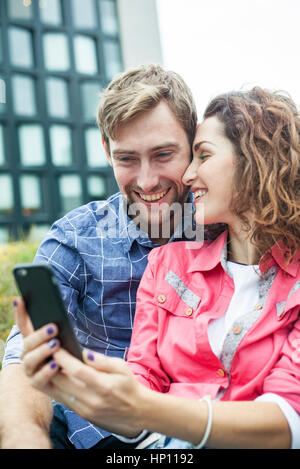 Couple using smartphone to take a selfie Stock Photo