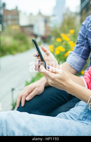 Couple using smartphone outdoors, cropped Stock Photo