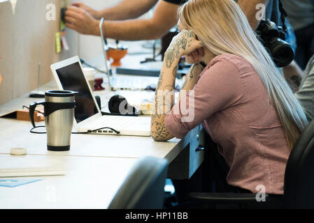 Woman concentrating on work in shared office space Stock Photo
