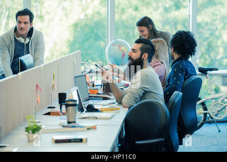 Workers talking in shared office space Stock Photo