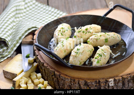 Traditional South Tyrolean cheese dumplings (so-called 'Kasnocken') made of white bread and hearty mountain cheese, served with melted butter, grated Stock Photo