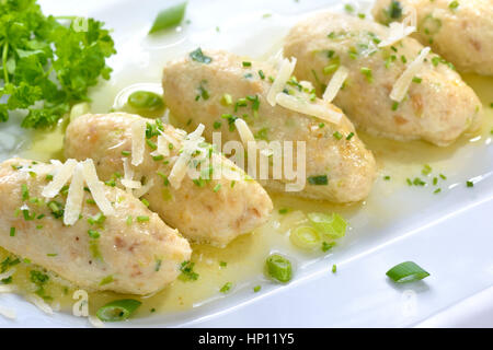 Traditional South Tyrolean cheese dumplings (so-called 'Kasnocken') made of white bread and hearty mountain cheese, served with melted butter, grated Stock Photo