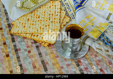 Jewish traditional Passover unleavened bread and a wine cup with the text of the traditional wine blessing Stock Photo