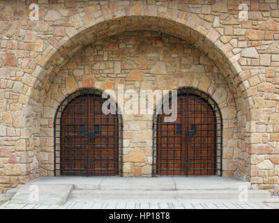 Double-arched stone temple entrance closed iron bars. Stock Photo