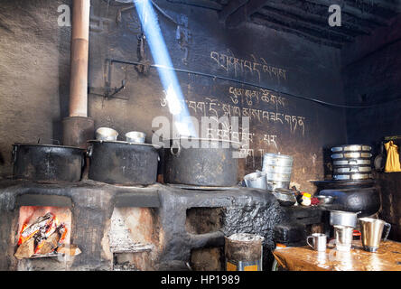 KEY MONASTERY, INDIA - APRIL 28, 2016: a ray of sunlight shines through the chimney creating sublime atmosphere in the kitchen- hall of an ancient Bud Stock Photo