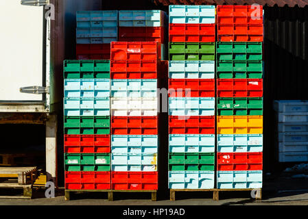 Nogersund, Sweden - February 14, 2017: Documentary of colorful fish crates stacked on wooden pallets in fishing port. Stock Photo
